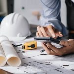 Image of engineer drawing a blue print design building or house, An engineer workplace with